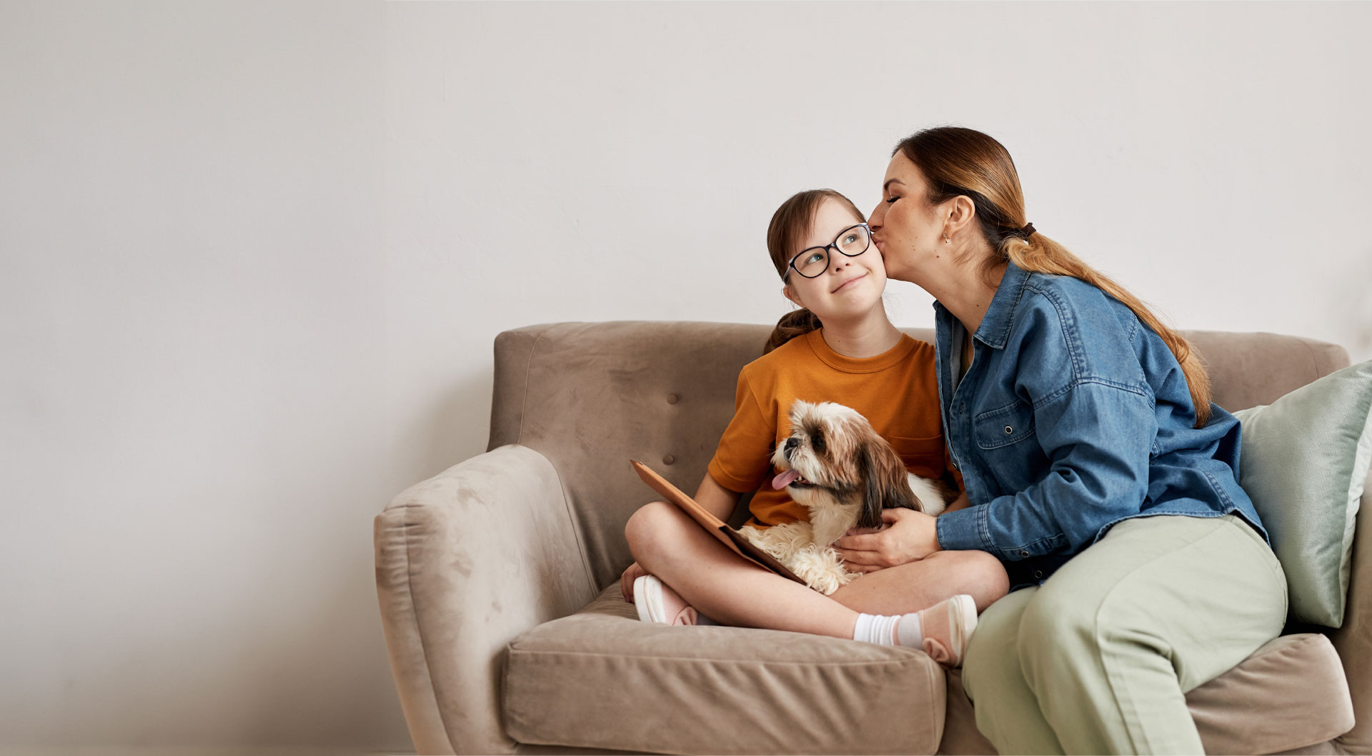 a person kissing a child on a couch